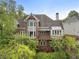 Rear view of red brick home featuring a deck, large windows, and lush landscaping at 4223 Wieuca Overlook Ne, Atlanta, GA 30342