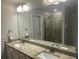 Bathroom featuring a double vanity with granite countertop, framed mirror and tiled walk-in shower at 82 Hinton Farm Way, Dacula, GA 30019