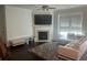 Cozy living room with a fireplace, large windows, and comfortable seating arrangements at 82 Hinton Farm Way, Dacula, GA 30019