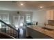 Open-concept kitchen and living space with granite countertops, stainless sink, and access to the backyard at 82 Hinton Farm Way, Dacula, GA 30019