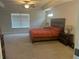 Spacious main bedroom with tray ceiling and a large window overlooking a quiet neighborhood at 82 Hinton Farm Way, Dacula, GA 30019