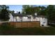 Rear exterior view featuring a deck, white brick, and lush landscaping at 9680 Ephesus Church Rd, Villa Rica, GA 30180
