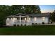 Beautifully landscaped white brick home featuring a cozy, covered front porch at 9680 Ephesus Church Rd, Villa Rica, GA 30180