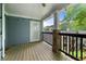 Covered balcony with wood floors, stone supports, and wooden railing at 1307 Madison Se Ln, Smyrna, GA 30080