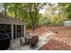 Secluded backyard patio featuring an outdoor dining set surrounded by mature trees and lush foliage at 2377 Emory Ln, Marietta, GA 30068