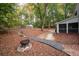 Enjoy the spacious backyard with fire pit, a stone walkway, and ample privacy provided by mature trees at 2377 Emory Ln, Marietta, GA 30068