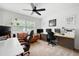Well-lit home office with multiple desks, comfortable seating, and a ceiling fan at 2377 Emory Ln, Marietta, GA 30068