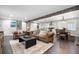 Open-concept living space with hardwood floors, dining area, a kitchen island with bar stools, and ample seating at 2377 Emory Ln, Marietta, GA 30068