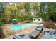 Inviting in-ground pool with ample lounge seating surrounded by a deck, mature trees and wooden fencing at 2377 Emory Ln, Marietta, GA 30068