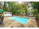 Sparkling in-ground pool surrounded by lush trees, wooden fencing, and comfortable lounge seating at 2377 Emory Ln, Marietta, GA 30068