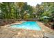 Private in-ground pool and stone patio, ideal for outdoor entertaining in a serene, wooded setting at 2377 Emory Ln, Marietta, GA 30068