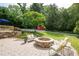 Backyard featuring brick patio, fire pit, ample seating, and lush landscaping at 3383 Campbell Se Rd, Smyrna, GA 30080