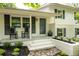 Inviting front porch with rocking chairs and manicured landscaping with dark shutters and a painted door at 3383 Campbell Se Rd, Smyrna, GA 30080