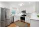 Modern kitchen with stainless steel appliances, white cabinets, and granite countertops at 3383 Campbell Se Rd, Smyrna, GA 30080