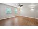 This bedroom features wood floors, a ceiling fan, windows, and neutral-colored walls at 798 Bankshire Dr, Suwanee, GA 30024