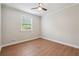 This bedroom features wood floors, a ceiling fan, a window, and neutral-colored walls at 798 Bankshire Dr, Suwanee, GA 30024