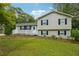 Charming two-story home with a white porch and surrounded by mature trees and lush landscaping at 798 Bankshire Dr, Suwanee, GA 30024