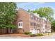 Charming brick townhome featuring black shutters, one car garage, and mature trees at 2301 Waters Edge Trl, Roswell, GA 30075