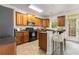 Well-lit kitchen features tile flooring, a breakfast bar, stainless steel appliances, and wooden cabinetry at 2301 Waters Edge Trl, Roswell, GA 30075