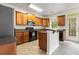 Well-lit kitchen features tile flooring, a breakfast bar, stainless steel appliances, and wooden cabinetry at 2301 Waters Edge Trl, Roswell, GA 30075