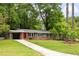 Charming single-story home with brick accents, a covered carport, a well-manicured lawn and a red front door at 3007 Stratford Arms Dr, Chamblee, GA 30341