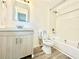 Updated bathroom featuring a modern vanity, toilet, and shower/tub combo with clean, white tile at 326 Old Farm Road, Woodstock, GA 30188