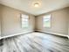 Spacious bedroom with wood-look flooring, two windows, and overhead lighting at 326 Old Farm Road, Woodstock, GA 30188