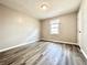 Well-lit bedroom with wood-look flooring, neutral walls, and a single window at 326 Old Farm Road, Woodstock, GA 30188