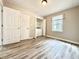 Bedroom with a laundry closet, double closets, wood-look flooring, and neutral walls at 326 Old Farm Road, Woodstock, GA 30188