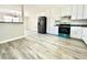 A modern kitchen that opens to the living area, featuring stainless steel appliances and gray vinyl flooring at 326 Old Farm Road, Woodstock, GA 30188