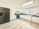 Modern kitchen featuring white cabinets, stainless steel appliances, and gray vinyl flooring at 326 Old Farm Road, Woodstock, GA 30188