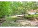 View of the large backyard showing the fence, level lawn, and mature trees at 3493 Wood Acres Blvd, Duluth, GA 30096
