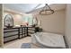 Luxurious bathroom with jacuzzi tub, skylight, dual vanities, and chandelier lighting at 3493 Wood Acres Blvd, Duluth, GA 30096