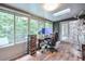 Bright home office with a desk and lots of windows looking out into a lush green background at 3493 Wood Acres Blvd, Duluth, GA 30096