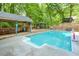 Inviting in-ground pool with pool house and gazebo surrounded by lush greenery at 3493 Wood Acres Blvd, Duluth, GA 30096