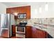 Modern kitchen with stainless steel appliances, granite countertops, and rich wood cabinetry at 898 Oak Sw St # 3207, Atlanta, GA 30310