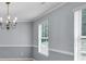 Elegant dining room with chandelier, windows, and chair rail molding at 1220 Skipping Rock Sw Ln, Grayson, GA 30017