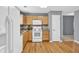 Well-lit kitchen with wood floors, gray walls, wooden cabinets and white appliances at 1220 Skipping Rock Sw Ln, Grayson, GA 30017