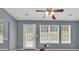 Relaxing living room with a ceiling fan, rear door, and three windows at 1220 Skipping Rock Sw Ln, Grayson, GA 30017