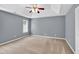 Spacious main bedroom with carpet, ceiling fan, and a window for natural light at 1220 Skipping Rock Sw Ln, Grayson, GA 30017