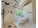 Modern bathroom showcasing a soaking tub, walk-in shower, and scenic views from the window at 2478 Roseberry Ln, Grayson, GA 30017