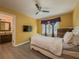 Cozy bedroom featuring yellow walls, TV, ceiling fan, and an adjoining bathroom for added convenience at 2478 Roseberry Ln, Grayson, GA 30017