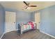 Light blue bedroom features a ceiling fan and light gray wood-look flooring at 2478 Roseberry Ln, Grayson, GA 30017