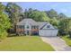 Charming two-story home boasts a manicured lawn and three-car garage, set amongst mature trees at 2478 Roseberry Ln, Grayson, GA 30017
