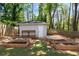 Backyard featuring a shed with wooden benches and plant beds ready for planting in the lush, green yard at 2553 Creekwood Ter, Decatur, GA 30030