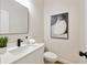 Stylish half bathroom with a modern vanity, framed mirror, contemporary art, and black hardware at 2553 Creekwood Ter, Decatur, GA 30030