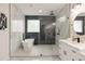 Bathroom featuring marble tile, soaking tub, walk-in glass enclosed shower, and modern finishes at 2553 Creekwood Ter, Decatur, GA 30030