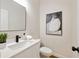 Modern half-bath featuring white vanity, black hardware, and a stylish mirror and artwork at 2553 Creekwood Ter, Decatur, GA 30030