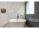 Bathroom features white marble tile, free-standing soaking tub, and black matte fixtures at 2553 Creekwood Ter, Decatur, GA 30030