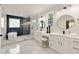 Bright and modern bathroom with tub, rain shower, glass doors, vanity and marble floors at 2553 Creekwood Ter, Decatur, GA 30030